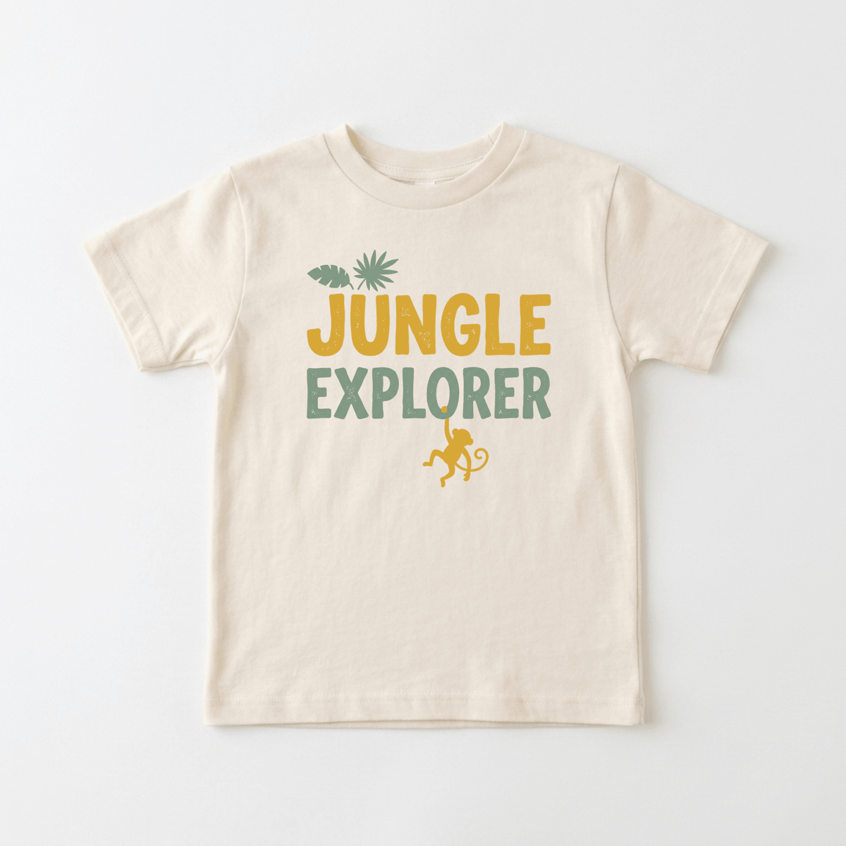 The Jungle Explorer Toddler Shirt – Monkey Safari Tee by Toodleroos features “JUNGLE EXPLORER” in vibrant yellow and green lettering, a green leaf above, and a playful yellow monkey graphic below—the ideal nature-loving toddler gift and the perfect tee for little jungle explorers.