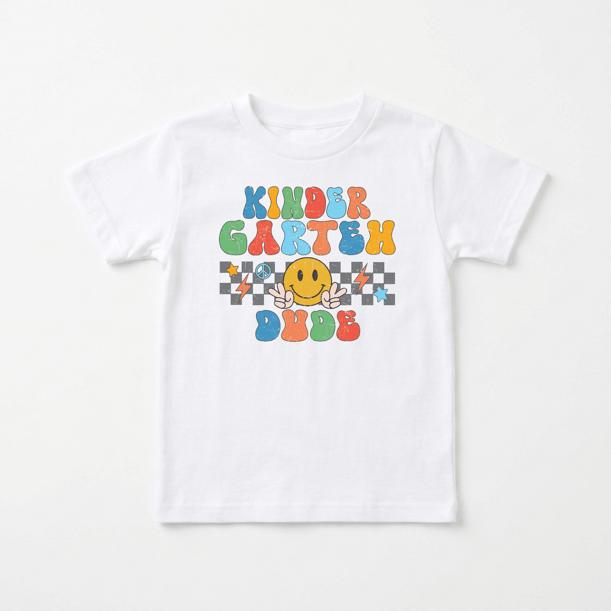 The Toodleroos Kindergarten Dude Youth Shirt – Retro Back to School Tee is a white T-shirt featuring colorful “Kindergarten Dude” text and a cheerful yellow character with raised hands, surrounded by checkered patterns and playful graphics—making it the perfect retro back-to-school shirt and an ideal choice for the first day of kindergarten.
