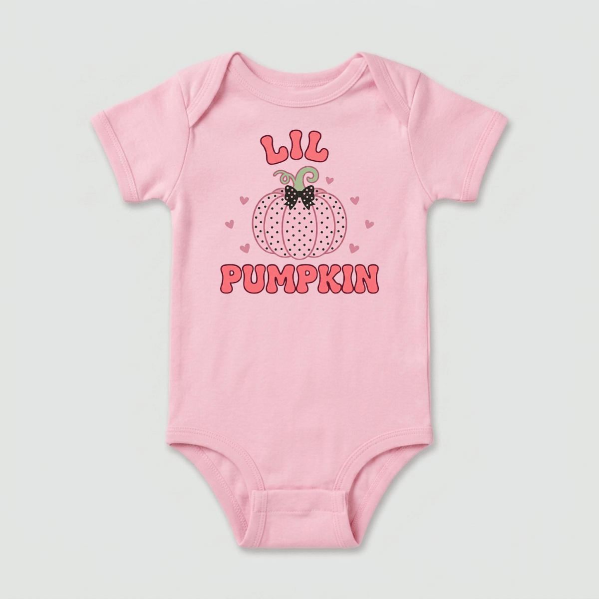 Dress your little one in the Toodleroos Lil Pumpkin Baby Onesie – Pink Polka Dot Bodysuit, featuring a sweet pumpkin graphic with “Lil Pumpkin” written in pink and red letters surrounded by tiny pink hearts. This adorable fall outfit is perfect for celebrating baby’s first autumn or capturing precious moments at the pumpkin patch.