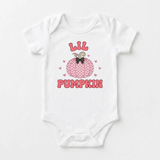 Dress your little one in the Lil Pumpkin Baby Onesie – Pink Polka Dot Bodysuit by Toodleroos, featuring a charming pink pumpkin illustration surrounded by dainty pink hearts. Bold, playful pink letters spell out “LIL” above the pumpkin and “PUMPKIN” below, making this onesie the perfect fall baby outfit or an adorable choice for your baby’s pumpkin patch photoshoot.