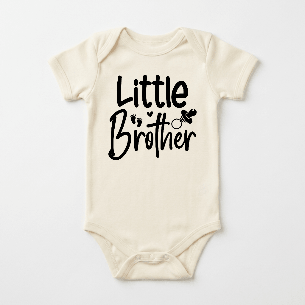 Dress your little one in the Toodleroos Little Brother Baby Onesie – Hand-Lettered Sibling Design, a soft cream-colored bodysuit adorned with “Little Brother” in bold black lettering, charming baby footprints, and a cute pacifier illustration. This cozy outfit is perfect as a coming home ensemble for your newest addition.