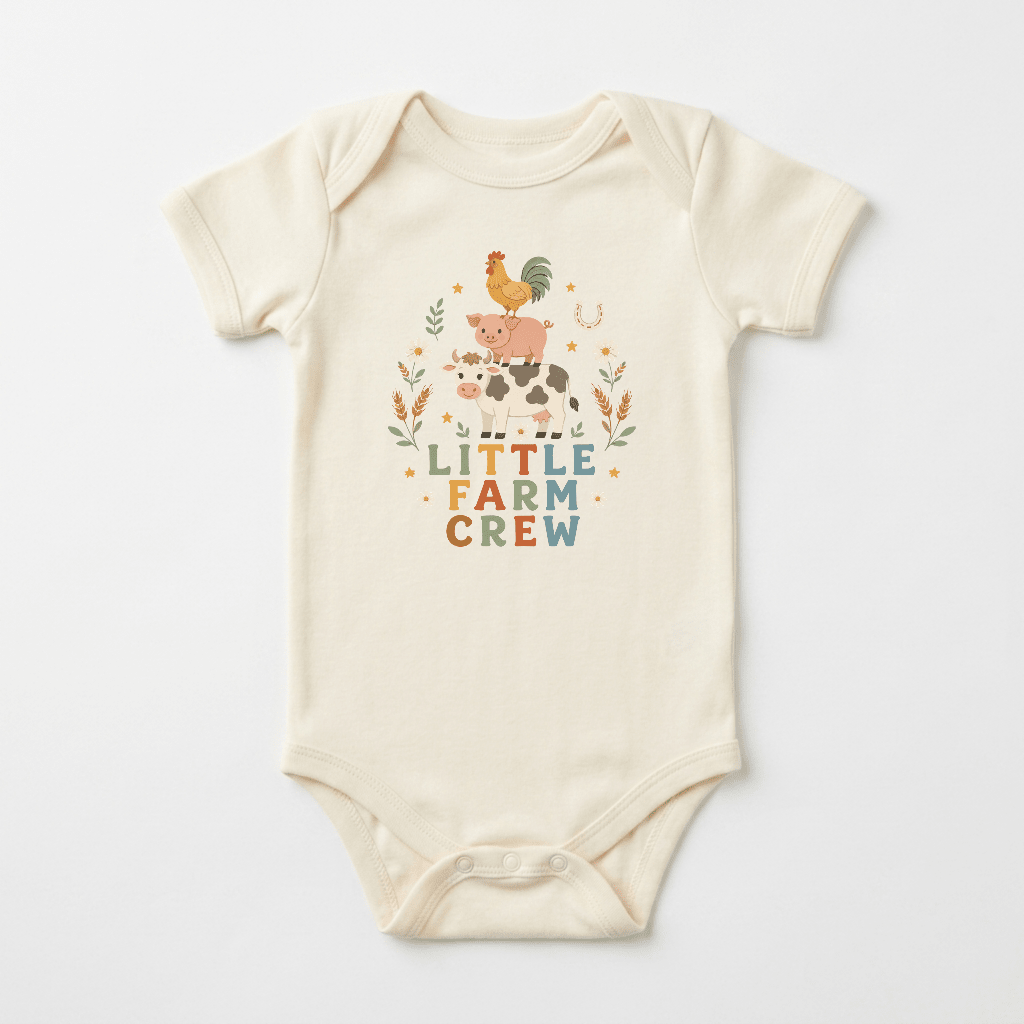 Dress your little one in the Toodleroos Little Farm Crew Farm Animal Baby Onesie, featuring a cream-colored design with whimsical illustrations of a rooster, pig, and cow stacked atop each other and surrounded by plants. The words “LITTLE FARM CREW” appear in colorful letters below the charming farm animals, making this country-inspired bodysuit an adorable choice for your baby.