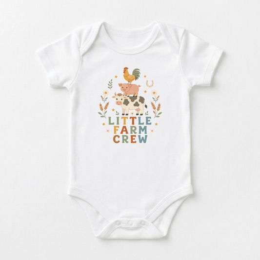 Dress your little one for country adventures in the Toodleroos Little Farm Crew Farm Animal Baby Onesie, a white onesie featuring adorable illustrations of a rooster, pig, and cow stacked above the phrase “LITTLE FARM CREW,” surrounded by whimsical leaves and stars. This charming onesie is the perfect addition to any boho baby clothes collection.
