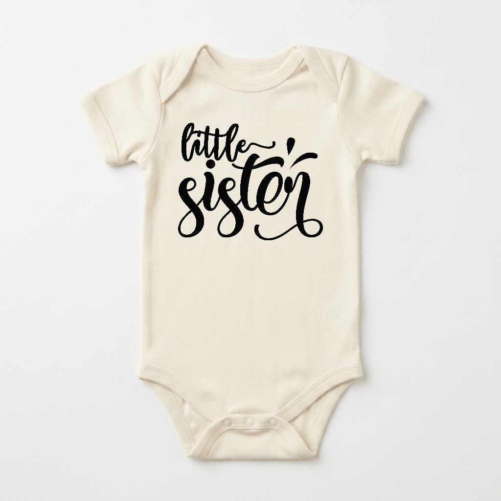 Dress your little one in the Toodleroos Little Sister Baby Onesie – Hand-Lettered Sibling Design, a cream-colored bodysuit featuring “little sister” in black cursive on the front—ideal for sibling outfits and celebrating your newest addition.