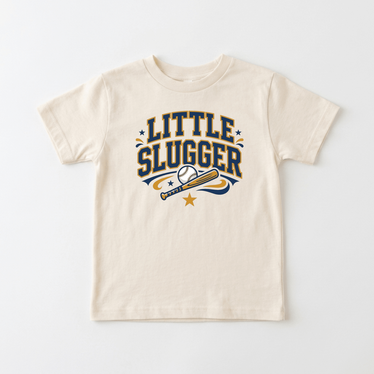 The Toodleroos Little Slugger Toddler Boys Baseball Shirt – Varsity Tee is a cream-colored baseball tee featuring “LITTLE SLUGGER” lettering above a graphic of a baseball bat, baseball, and star, adorned with small stars plus blue and gold accents—an ideal varsity-style shirt for toddler fans.