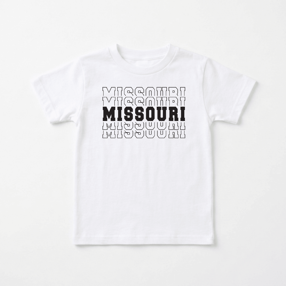 The Toodleroos Missouri Varsity Kids Shirt – State Pride Tee features the word “MISSOURI” printed three times in outlined text, with the center “MISSOURI” in bold, solid black letters—a classic kids’ shirt that celebrates hometown pride. The shirt is displayed flat on a white background.