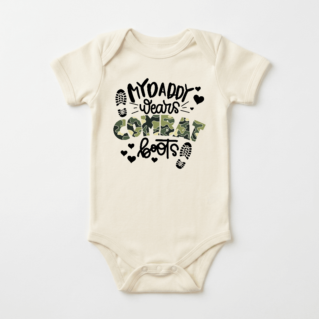Dress your little one in the Toodleroos “My Daddy Wears Combat Boots Baby Onesie – Camo Design.” This beige baby bodysuit features the playful phrase “My daddy wears combat boots” in fun typography, with “combat” highlighted in a striking green camo pattern. Boot prints and tiny black hearts accent the design, making it an ideal gift for military dads.