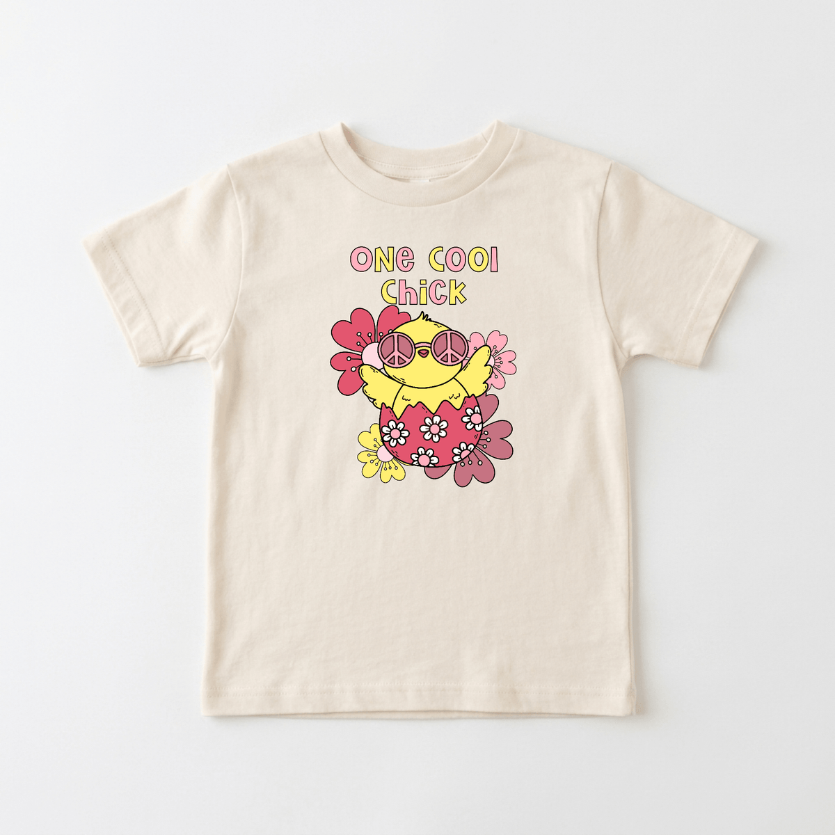 The Toodleroos One Cool Chick Kids Shirt – Easter Tee is a beige t-shirt featuring a cartoon chick in pink sunglasses, surrounded by playful pink and yellow flowers with “One Cool Chick” printed above the design—making it an ideal kids’ Easter shirt or cheerful spring outfit that’s perfect for sibling sets.