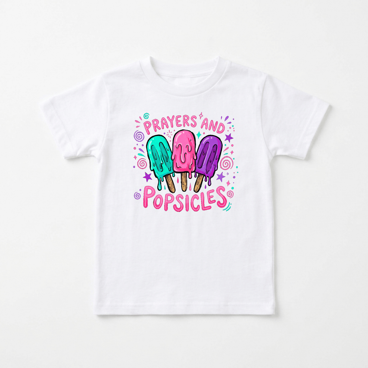 The Prayers and Popsicles Kids Shirt – Summer Faith Tee by Toodleroos features a white t-shirt adorned with vibrant cartoon popsicles, playful “Prayers and Popsicles” lettering, and cheerful stars, dots, and swirls. This fun faith-themed tee is perfect for Vacation Bible School or any child wanting a bright and joyful Christian shirt.