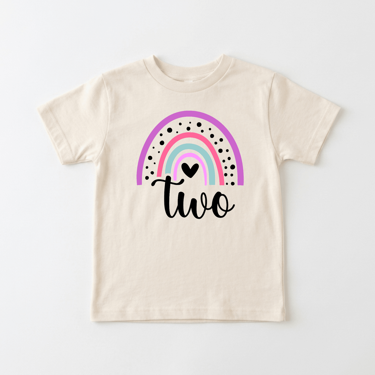 Celebrate your little one’s big day with the Rainbow Two Toddler Shirt – 2nd Birthday Tee from Toodleroos. This beige kids’ T-shirt features a pastel rainbow, black dots, a small heart, and the word “two” in script below the rainbow—making it an adorable choice for 2nd birthday shirts. Personalize this special tee to create a unique keepsake they’ll cherish!.