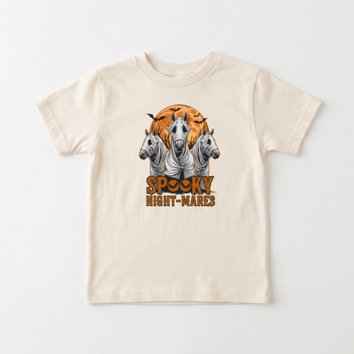 Dress your little one in the Toodleroos Spooky Night-Mares Toddler Shirt – Halloween Horse Tee, a beige shirt showcasing three white horses draped in ghost sheets, a big orange moon with bats flying above, and “Spooky Night-Mares” boldly printed in orange beneath the scene.