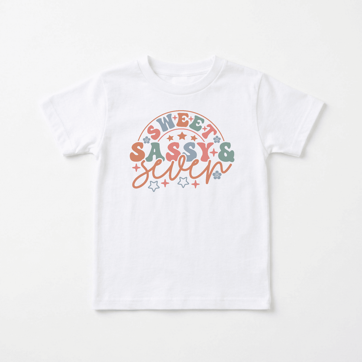 Dress your little one in the Toodleroos Sweet Sassy & Seven Kids Shirt – Retro 7th Birthday Tee, featuring a white base with colorful “Sweet, Sassy & Seven” text surrounded by pastel pink, green, and orange stars—a fun retro kids shirt that’s perfect as a 7th birthday shirt or pastel rainbow tee for their special day.