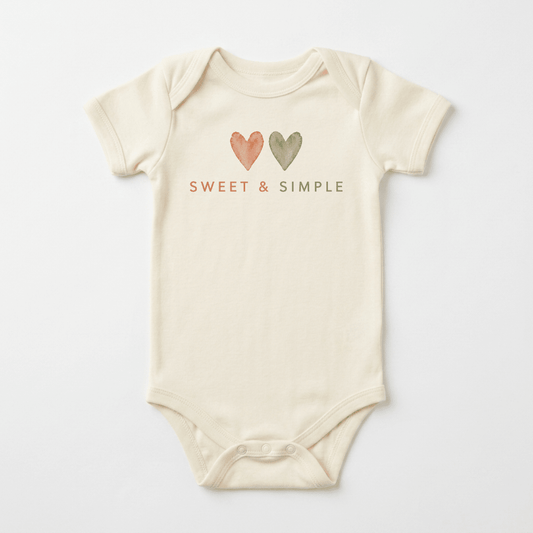 A cream-colored, gender-neutral baby onesie from Toodleroos, the Sweet & Simple Short-Sleeve Heart Bodysuit features two watercolor hearts—one orange and one green—placed above “SWEET & SIMPLE” printed in matching orange and green on the chest. This versatile piece of baby clothing makes a thoughtful shower gift for any little one.