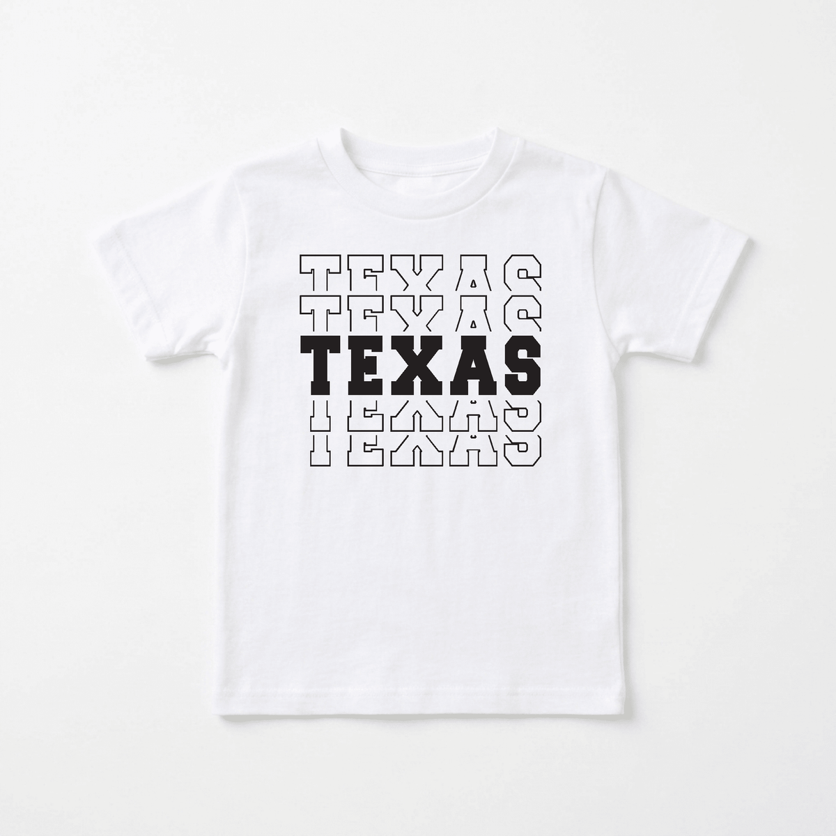 Showcase hometown pride with the Toodleroos Texas Varsity Kids Shirt – State Pride Tee. This white t-shirt features the word “TEXAS” repeated three times in large varsity-style letters: the middle TEXAS is bold and filled in black, while the top and bottom are outlined in black. Perfect for little ones, this Texas kids shirt offers a sporty look that’s ideal for showing off their state pride.