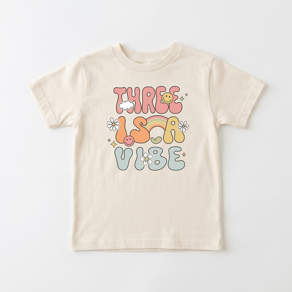 Celebrate your little one’s special day with the Toodleroos Three Is a Vibe Toddler Shirt – a retro 3rd birthday tee featuring playful multicolored text, smiley faces, flowers, and a rainbow on a beige t-shirt—perfect for toddlers who love fun vintage-inspired kids shirts.
