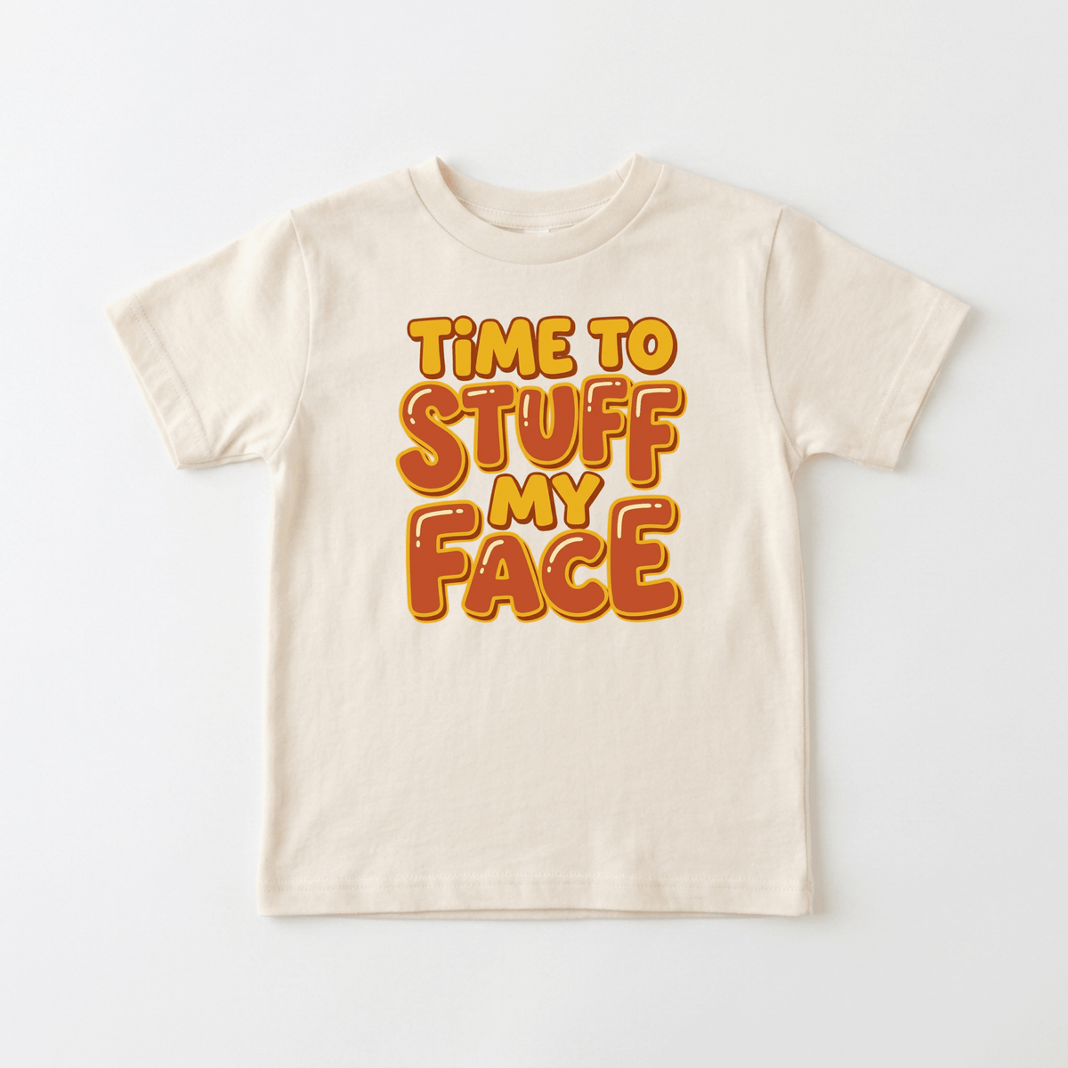 Dress your little one for the holidays in the Toodleroos Time to Stuff My Face Thanksgiving Toddler Shirt – a beige tee featuring bold orange and yellow “TIME TO STUFF MY FACE” text centered on the front. This funny Turkey Day tee is perfect for adding a playful touch to any toddler’s holiday outfit.