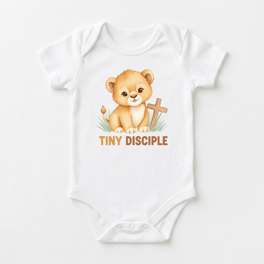 The Toodleroos Tiny Disciple Baby Onesie – Christian Lion Design features a charming white lion cub sitting beside a wooden cross, with “TINY DISCIPLE” printed in brown letters underneath—making it the perfect Christian baby onesie and a meaningful baptism gift.