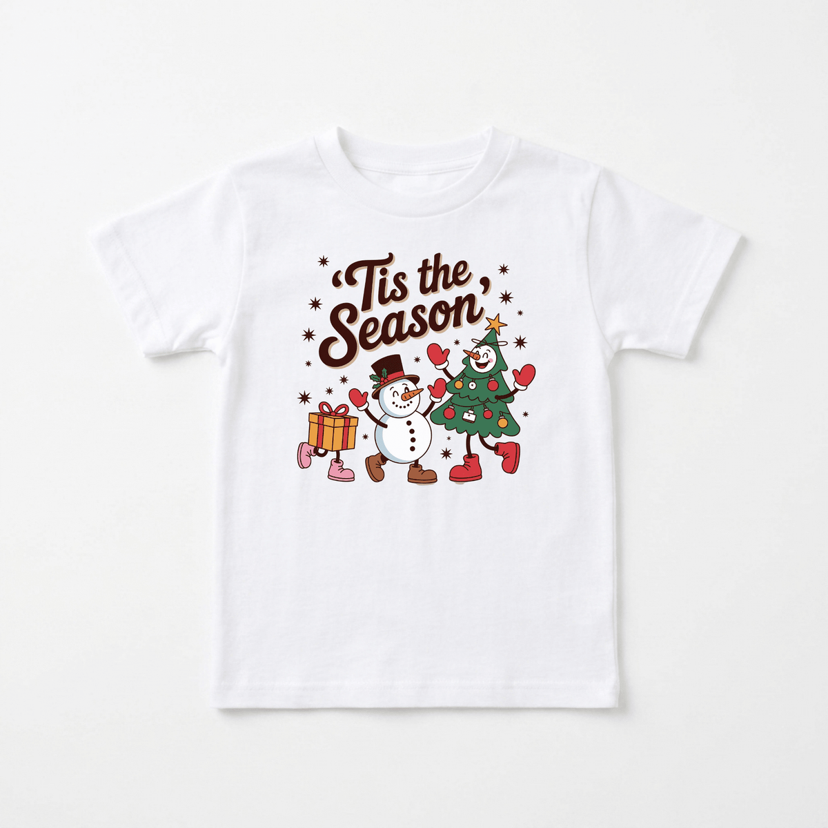 Dress your child for the holidays with the Toodleroos ’Tis the Season Toddler Tee – Retro Christmas Kids Shirt! This cheerful white shirt features a festive scene: a smiling snowman, a Christmas tree, and a gift box holding hands, all surrounded by sparkling stars. Above them, “Tis the Season” is written in fancy brown letters. Infuse your little one’s wardrobe with vintage-inspired charm—this fun holiday tee is perfect for toddlers who love classic Christmas spirit!.