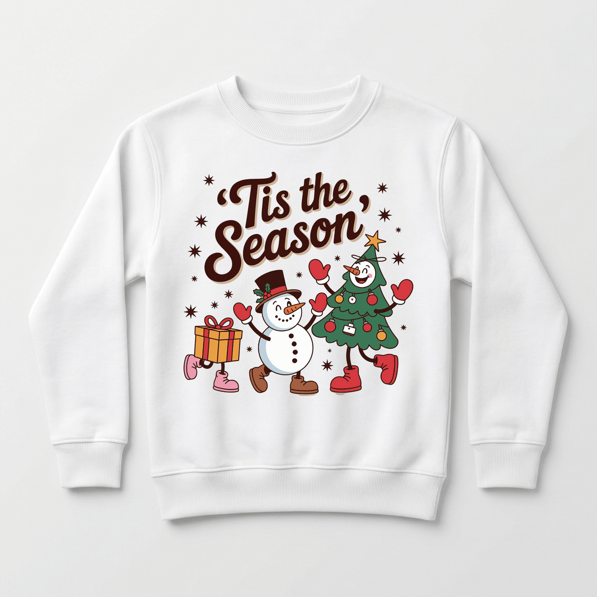 The Toodleroos ’Tis the Season Retro Christmas Toddler Sweatshirt features a cheerful design with a smiling snowman and a Christmas tree character holding hands, surrounded by snowflakes and a gift box—making it the perfect festive sweatshirt for toddler holiday celebrations.