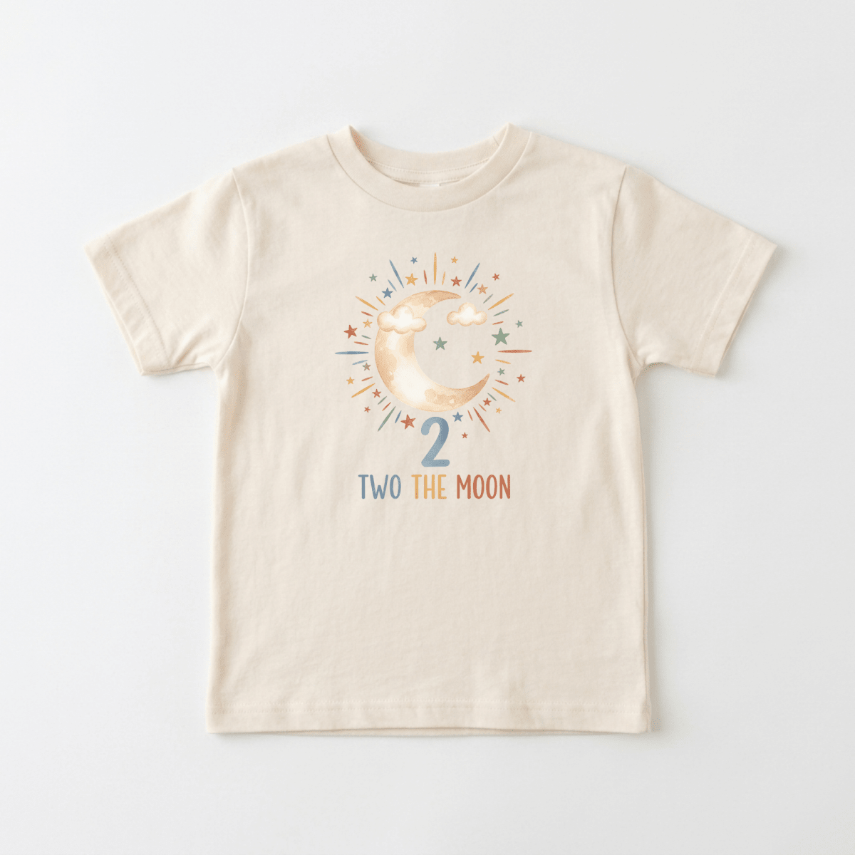 Dress your little one in the perfect 2nd birthday outfit with this cream-colored “2nd Birthday Toddler Shirt – Two the Moon Celestial Short-Sleeve Tee” by Toodleroos. It features a cheerful crescent moon and clouds surrounded by colorful stars, the number 2 underneath, and the fun phrase “TWO THE MOON” in multicolored letters—making it an ideal shirt for your toddler’s special day.
