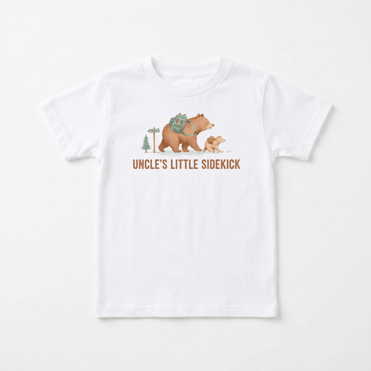 Introducing the Toodleroos Uncle’s Little Sidekick Toddler Shirt – Hiking Bear Tee! This adorable white t-shirt features a delightful illustration of a big bear and a little bear strolling together beneath the words “UNCLE’S LITTLE SIDEKICK,” set amidst a whimsical hiking scene with trees and a signpost. Perfect as an uncle toddler shirt, this hiking bear tee makes a heartwarming gift for your little one and their favorite uncle.