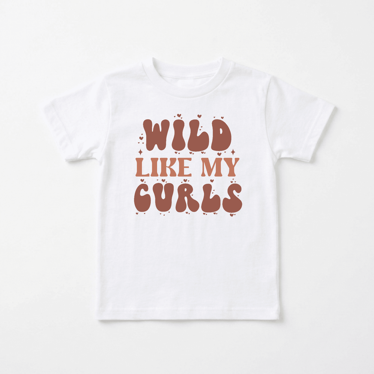 The Toodleroos Wild Like My Curls Kids Shirt – Boho Retro Tee features a white design with the phrase “WILD LIKE MY CURLS” in bold, playful brown bubble letters, accented by small hearts and sparkles—a perfect retro shirt for little ones who want to show off their curls.