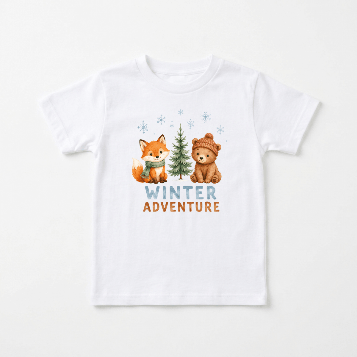 Dress your little one in the Toodleroos Winter Adventure Toddler Shirt – Woodland Animal Design. This cozy white tee features a charming illustration of a fox wearing a scarf and a bear sporting a hat, standing beside a pine tree. Blue snowflakes fall around them, with “WINTER ADVENTURE” artistically printed below in blue and orange letters. It’s the perfect woodland toddler shirt for chilly days or festive outings!.
