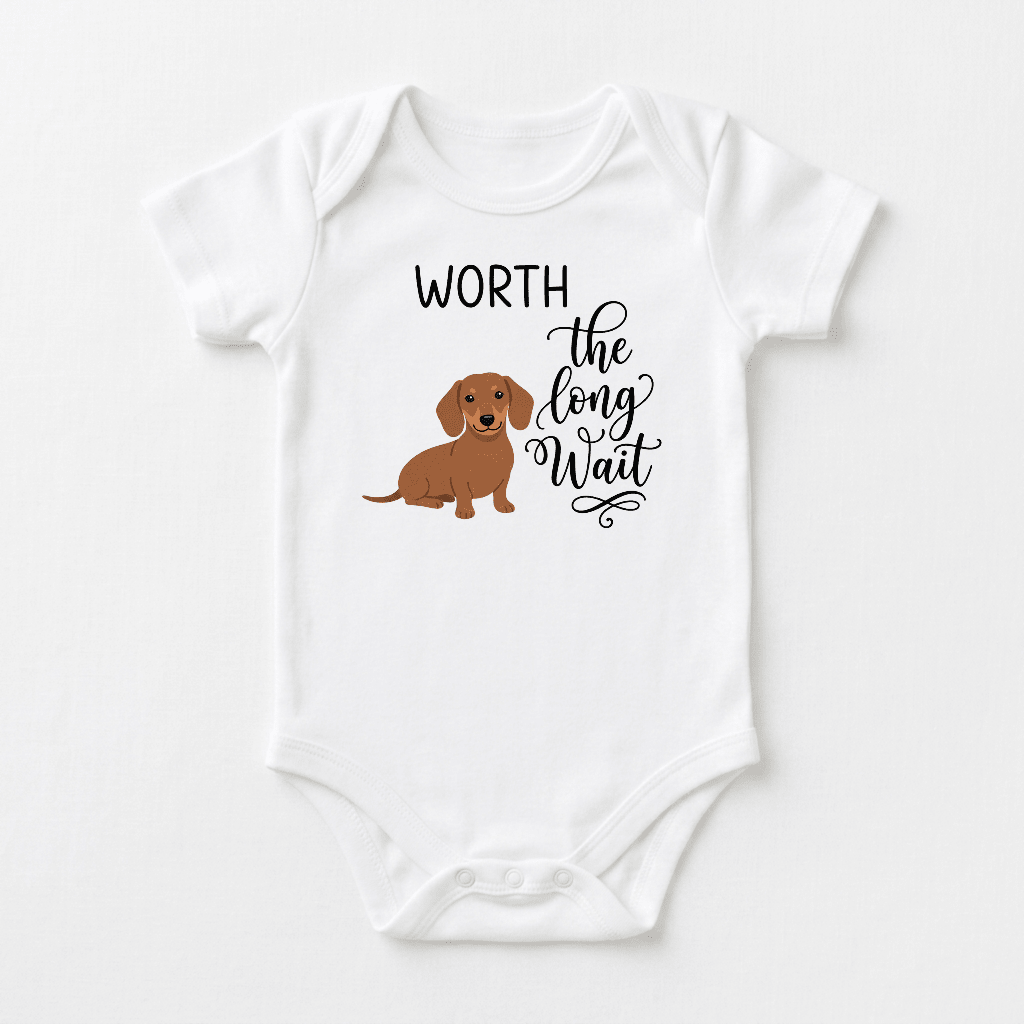 Introducing the Worth the Long Wait Onesie – Baby Announcement Bodysuit by Toodleroos. This white baby bodysuit features a charming brown dachshund graphic and the phrase “WORTH the long Wait” in stylish black decorative lettering—an ideal choice as a rainbow baby onesie or for celebrating your little one after a fertility journey.